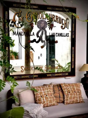 a mirror on the wall above a couch in a living room at La Alberca de Fariñas in Sanlúcar de Barrameda