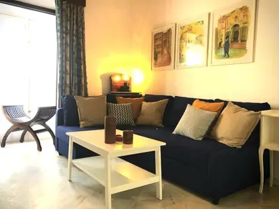 a living room with a blue couch and a table at La Alberca de Fariñas in Sanlúcar de Barrameda