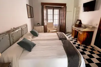 a large bed in a room with a desk at La Alberca de Fariñas in Sanlúcar de Barrameda