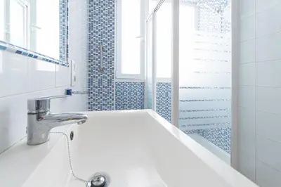 a white bathroom with a sink and a mirror at Apartamento las Jacarandas de Cadiz in Cádiz