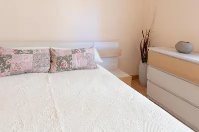 a bedroom with a bed with two pillows and a dresser at Apartamento las Jacarandas de Cadiz in Cádiz
