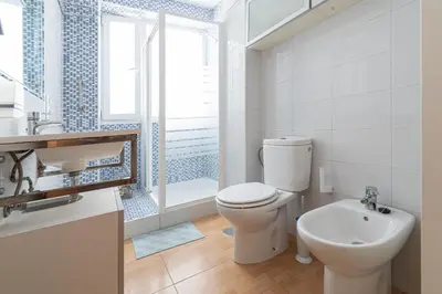 a white bathroom with a toilet and a sink at Apartamento las Jacarandas de Cadiz in Cádiz