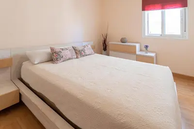 a bedroom with a large white bed with two pillows at Apartamento las Jacarandas de Cadiz in Cádiz