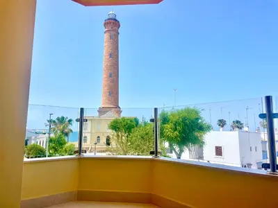 a view of a lighthouse from a room with a window at vistas maravillosas in Chipiona