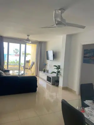a living room with a couch and a table and a tv at vistas maravillosas in Chipiona