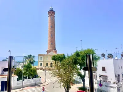 a tall brick tower in front of a building at vistas maravillosas in Chipiona