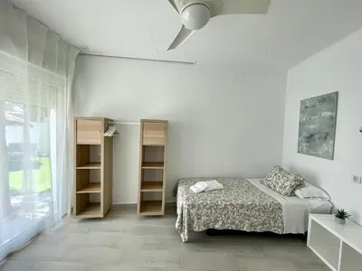 a bedroom with a bed and shelves and a ceiling fan at Minichalet El Molino 5 in Chiclana de la Frontera