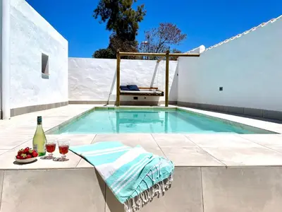 a swimming pool with a swing next to a house at Minichalet El Molino 5 in Chiclana de la Frontera