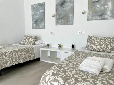 a bedroom with two beds and a white table at Minichalet El Molino 5 in Chiclana de la Frontera