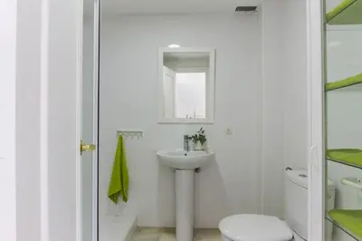 a white bathroom with a sink and a toilet at Duplex Terraza Rivera Marisco 2 Dormitorios 2 Baños in El Puerto de Santa María