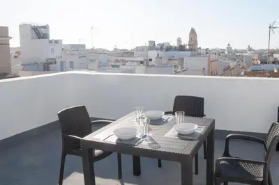 a table and chairs on a balcony with a view at El mirador de Ancha in Cádiz