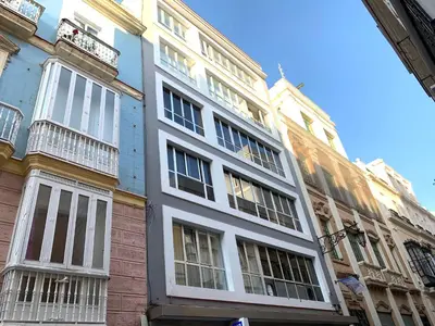 a large white building with windows on a street at El mirador de Ancha in Cádiz