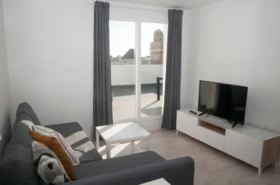 a living room with a couch and a television at El mirador de Ancha in Cádiz