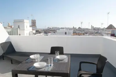 a table and chairs on a balcony with a view at El mirador de Ancha in Cádiz