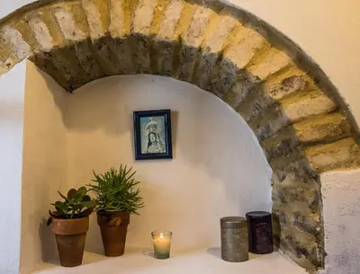 an archway in a wall with plants and candles at CASA PACO - Casita con Encanto in Medina Sidonia