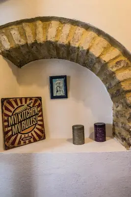 a room with a stone wall with two candles on a shelf at CASA PACO - Casita con Encanto in Medina Sidonia