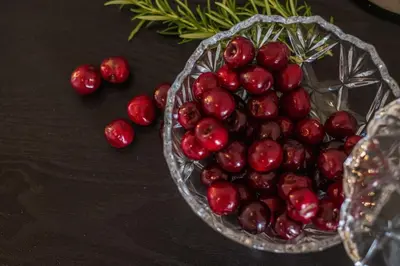 a bowl of cherries on a table next to a glass plate at CASA PACO - Casita con Encanto in Medina Sidonia