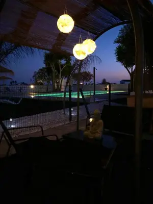 a person sitting on a swing in the dark at Villas Santa Ana in Conil de la Frontera