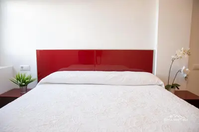 a bed with a red headboard and white sheets at Apartamento Cañadilla MRZ Rentals in El Puerto de Santa María