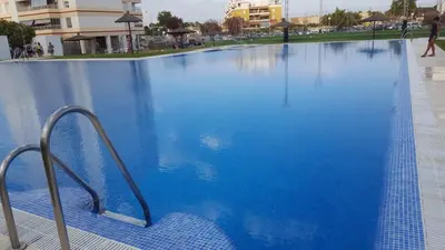 a large swimming pool with blue water at Apartamento Cañadilla MRZ Rentals in El Puerto de Santa María