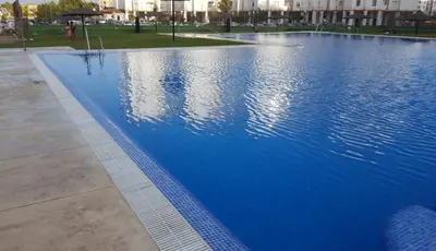 a large blue swimming pool in a park at Apartamento Cañadilla MRZ Rentals in El Puerto de Santa María