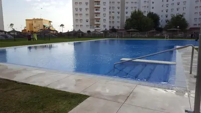 a large blue swimming pool in a city at Apartamento Cañadilla MRZ Rentals in El Puerto de Santa María