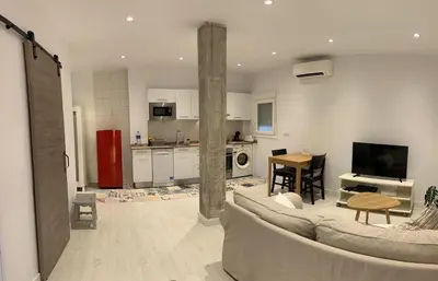 a living room with a couch and a kitchen at Sunset Caleta in Cádiz