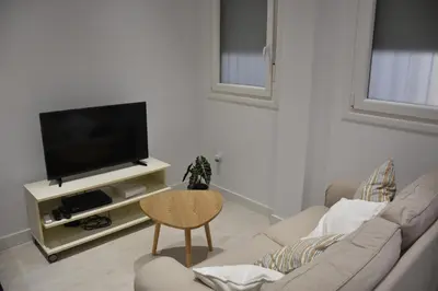 a living room with a couch and a tv at Sunset Caleta in Cádiz