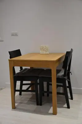 a wooden table with two black chairs around it at Sunset Caleta in Cádiz