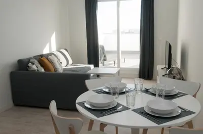 a living room with a white table and a couch at El mirador de Ancha in Cádiz