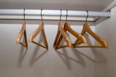 four wooden hangers are hanging on a rod at El mirador de Ancha in Cádiz