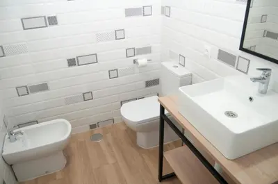 a white bathroom with a sink and a toilet at El mirador de Ancha in Cádiz