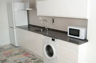 a kitchen with a washing machine and a microwave at El mirador de Ancha in Cádiz
