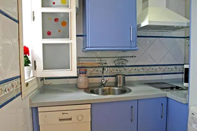 a kitchen with blue cabinets and a sink at DescubreHome Playa de la Caleta in Cádiz