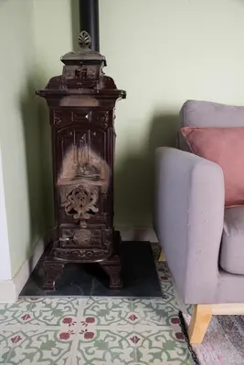 a wooden stove in a living room next to a couch at El ático de los mosaicos in Cádiz