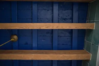 a wooden shelf in a room with blue walls at El ático de los mosaicos in Cádiz