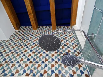 a bathroom with a shower with a tile floor at El ático de los mosaicos in Cádiz