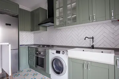 a kitchen with green cabinets and a washing machine at El ático de los mosaicos in Cádiz