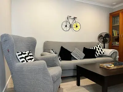 a living room with a couch and a bike on the wall at Lemon Tree Corazón de Cádiz Grupo AC Gestion in Cádiz