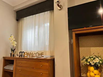 a room with a dresser and a television on a wall at Lemon Tree Corazón de Cádiz Grupo AC Gestion in Cádiz