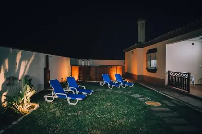 a group of chairs sitting on a yard at night at La Guareña in Chiclana de la Frontera