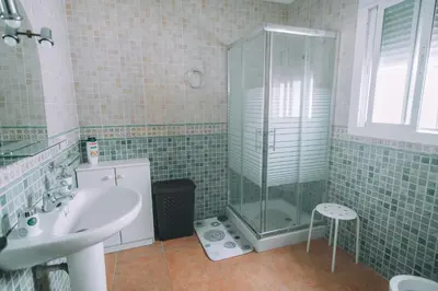 a bathroom with a glass shower and a sink at La Guareña in Chiclana de la Frontera