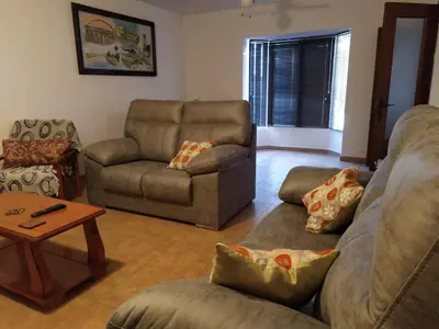 a living room with a couch and chairs and a table at La Guareña in Chiclana de la Frontera