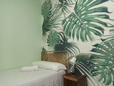 a bedroom with a wall mural of tropical plants at Viña 41 in Cádiz