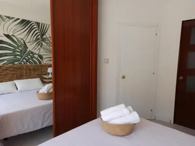 a bedroom with a bed and a mirror with towels at Viña 41 in Cádiz