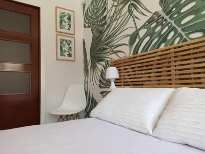 a bedroom with a white bed and a plant wall at Viña 41 in Cádiz