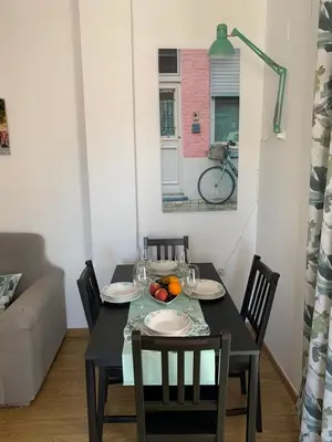 a dining room table with plates and fruit on it at ATICO LA ILUSION CON PARkING in Sanlúcar de Barrameda