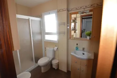 a bathroom with a toilet and a sink and a shower at ATICO LA ILUSION CON PARkING in Sanlúcar de Barrameda