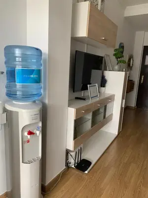 a living room with a water tank on top of a refrigerator at ATICO LA ILUSION CON PARkING in Sanlúcar de Barrameda
