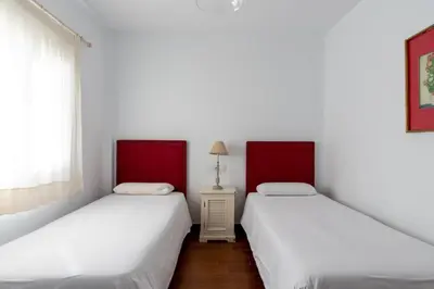 two beds in a room with white walls at Sanlúcar Olehousing in Sanlúcar de Barrameda